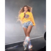 Do żółtej bluzy Beyonce dobrała krótkie jeansowe szorty i błyszczące kozaki z frędzlami.